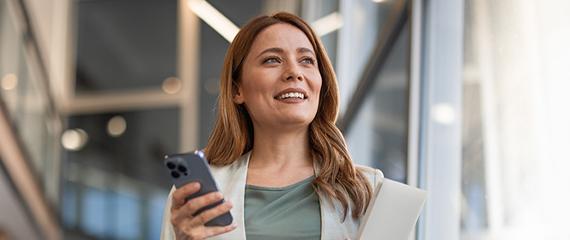 donna con smartphone in mano che guarda a destra | Crédit Agricole donna con smartphone in mano che guarda a destra | Crédit Agricole